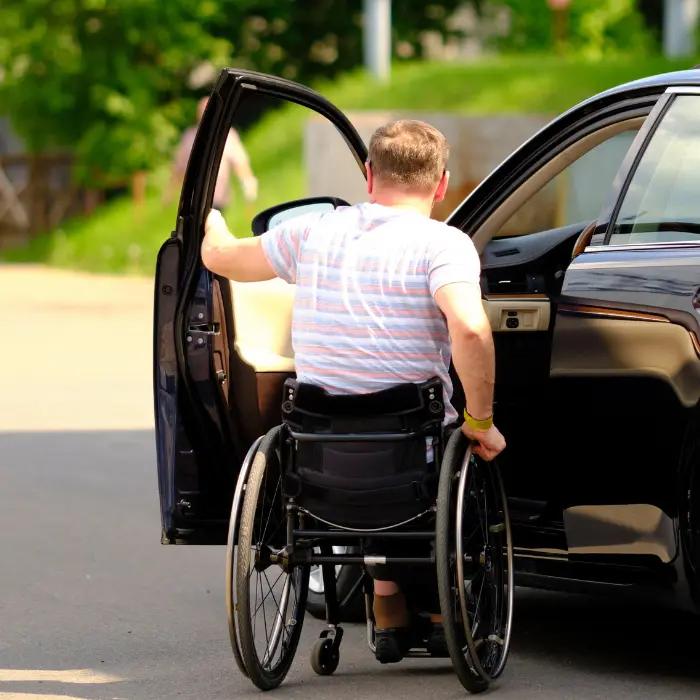 Disabled man in wheelchair getting into car