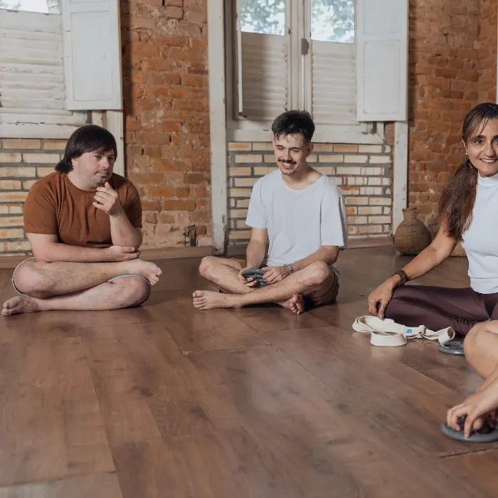Disabled man with down syndrome sitting cross legged on the floor in group class