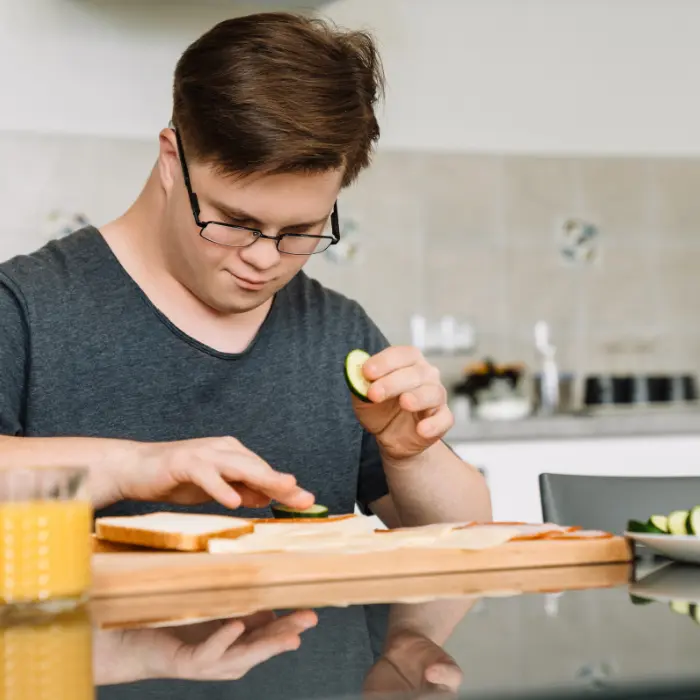 Disabled man with down syndrome making a sandwich
